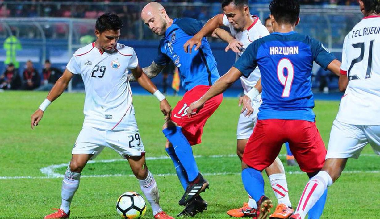 Striker Johor Darul Ta'zim, Luciano Figueroa, berusaha melewati gelandang Persija Jakarta, Sandi Sute pada laga AFC Cup di Stadion Hassan Yunos, Johor, Rabu (14/2/2018). JDT menang 3-0 atas Persija. (Media Persija)