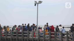 Pengunjung memadati kawasan Pantai Ancol di Taman Impian Jaya Ancol, Jakarta, Rabu (4/5/2022). Objek wisata tersebut kembali ramai dikunjungi wisatawan pada saat liburan Hari Raya Idul Fitri 1443 H setelah dua tahun sebelumnya sempat mengalami penurunan kunjungan wisatawan akibat pandemi Covid-19. (Liputan6.com/Herman Zakharia)
