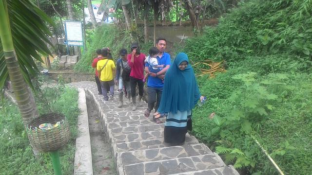 Para pengunjung tengah menuruni tangga menuju pemukiman penduduk ampung Naga Tasikmalaya