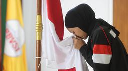 Pemain menyium bendera Merah Putih saat acara pelepasan Timnas Voli Putri Indonesia untuk mengikuti ajang AVC Nations Cup 2025 di Padepokan Bola Voli Jenderal Polisi Kunarto, Sentul, Bogor. Rabu (4/6/2025). (Bola.com/M Iqbal Ichsan)