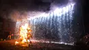 Seorang pria menyiram air pada patung karakter Donald Trump saat perayaan pembakaran Yudas di Mexico City, Meksiko (15/4). Pembakaran adalah bagian dari tradisi Meksiko dalam Minggu Suci Paskah. (AP Photo/Rebecca Blackwell)