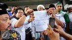 Perwakilan organisasi massa menunjukkan berkas laporan usai melaporkan Gubernur DKI Jakarta, Basuki Tjahaja Purnama ke Bareskrim Mabes Polri di KKP, Jakarta, Jumat (7/10). Ahok dilaporkan atas dugaan penodaan agama. (Liputan6.com/Helmi Fithriansyah)