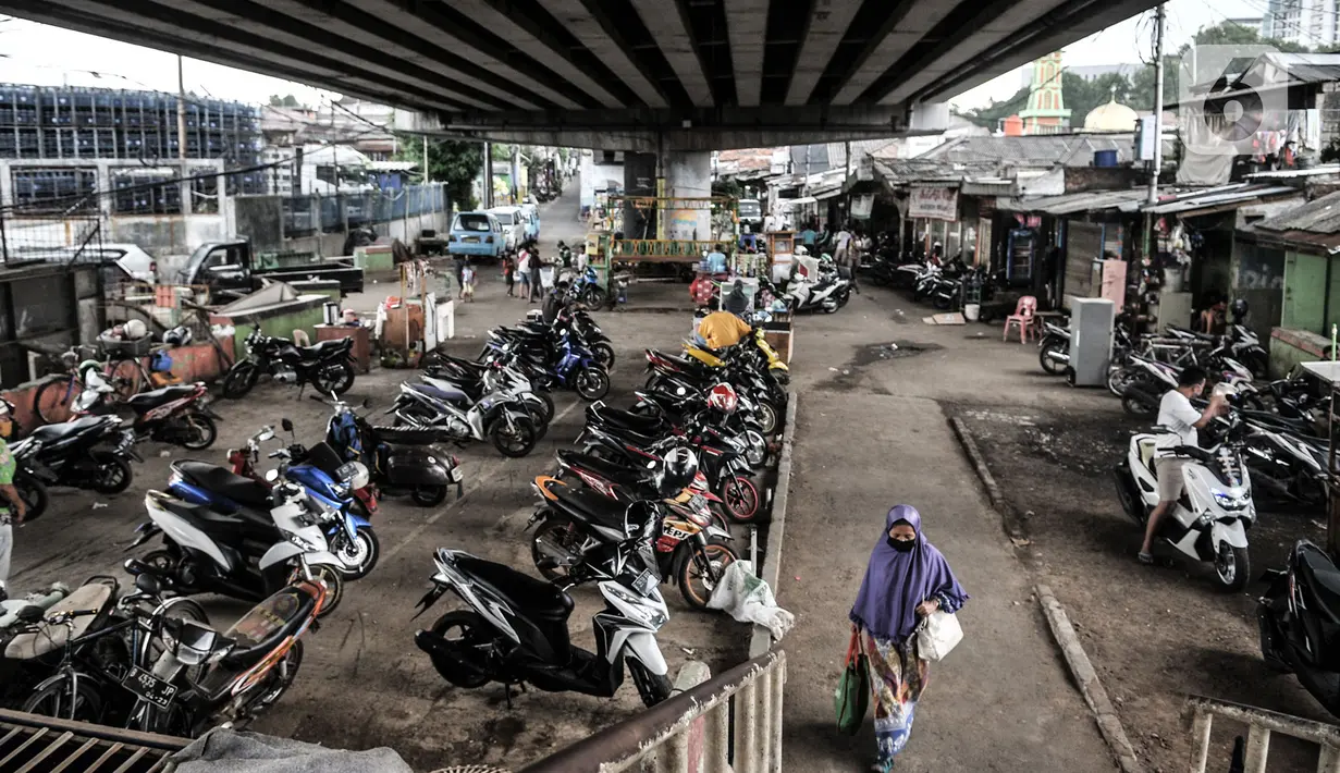 Warga saat melintas di area parkir motor warga yang juga merupakan salah satu lokasi pengungsian ketika banjir di kawasan RW 07 Rawajati, Jakarta, Selasa (22/9/2020). (merdeka.com/Iqbal S. Nugroho)