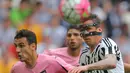 Striker Juventus, Mario Mandzukic, duel udara dengan pemain Palermo pada laga Serie A di Stadion Juventus, Turin, Minggu (17/4/2016). Kemenangan ini membuat Juve kian kokoh di puncak klasemen. (AFP/Marco Bertorello)