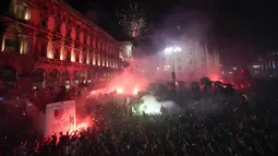 Ribuan penggemar bersorak saat bus yang membawa para pemain tim sepak bola AC Milan melakukan parade kemenangan Liga Italia di depan Katedral Gotik Milan, Milan, Italia, 23 Mei 2022. (AP Photo/Luca Bruno)