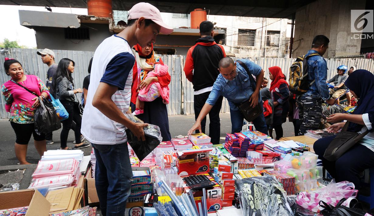 Warga memilih peralatan sekolah yang dijajakan pedagang di sekitar Pasar Asemka, Jakarta, Rabu (5/7). Jelang bergantinya tahun ajaran baru, sejumlah warga berburu peralatan sekolah di kawasan Pasar Asemka Jakarta. (Liputan6.com/Helmi Fithriansyah)