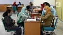 Petugas kesehatan mendata warga yang menjalani vaksinasi booster kedua atau dosis keempat di kawasan Kantor Wali Kota Jakarta Timur, Jakarta, Selasa (24/1/2023). Aturan vaksinasi booster kedua diumumkan Kementerian Kesehatan (Kemenkes) melalui Surat Edaran (SE) Nomor HK.02.02/C/380/2023 tentang Vaksinasi COVID-19 Dosis Booster Ke-2 Bagi Kelompok Masyarakat Umum yang diteken oleh Direktur Jenderal Pencegahan dan Pengendalian Penyakit (Dirjen P2P) Maxi Rein Rondonuwu pada 20 Januari 2023. (Liputan6.com/Johan Tallo)