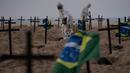 Aktivis menggali kuburan di pantai Copacabana, Rio de Janeiro, Kamis (11/6/2020). Aksi simbolis yang dilakukan oleh kelompok LSM Rio de Paz itu sebagai bentuk protes atas respons pemerintah Brasil dalam menangani pandemi Covid-19. (AP Photo/Leo Correa)