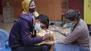 Perempuan yang mengenakan masker mendapatkan desain henna di tangan mereka pada malam festival Karva Chauth di New Delhi, India, Selasa (3/11/2020). Ini adalah festival untuk memulai bulan baru di bulan November di mana para istri akan berpuasa untuk suami-suami mereka. (AP Photo/Manish Swarup)