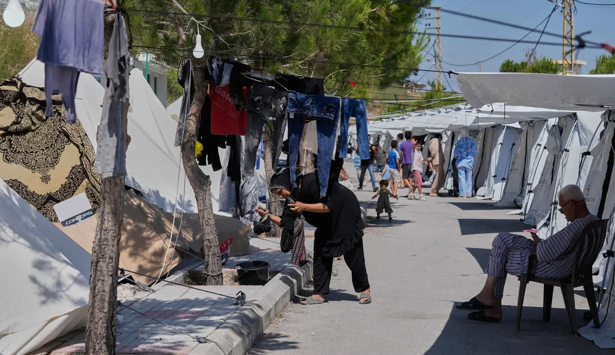 Seorang wanita pengungsi yang meninggalkan desanya di Lebanon Selatan menjemur pakaian di luar tenda di sebuah gang kota pelabuhan Sidon, Rabu 10 Juni 2026. (AP Photo/Mohammed Zaatari)