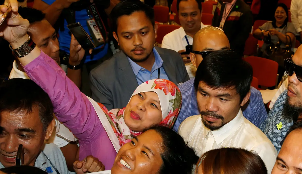 Pendukung berselfie dengan bintang tinju Filipina dan Senator Manny Pacquiao setelah dia dinyatakan oleh pejabat pemilu sebagai salah satu dari 12 anggota baru dari majelis tinggi Kongres di Manila, Filipina (19/5). (REUTERS/Erik De Castro)