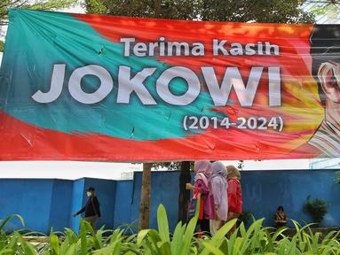Warga berjalan di dekat baliho bertuliskan Terima Kasih Jokowi di Jalan Jenderal Sudirman, Jakarta Kamis (17/10/2024). (Liputan6.com/Angga Yuniar)