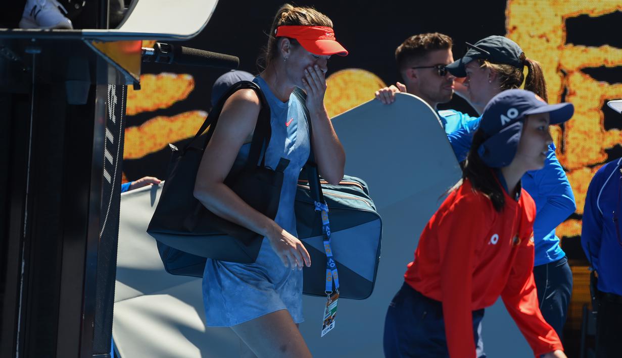 Petenis Rusia Maria Sharapova meninggalkan Rod Laver Arena setelah kalah atas Ashleigh Barty dari Australia pada babak keempat Australia Terbuka 2019 di Melbourne, Australia (20/1). Sharapova kalah 4-6 6-1 6-4. (AFP Photo/Greg Wood)
