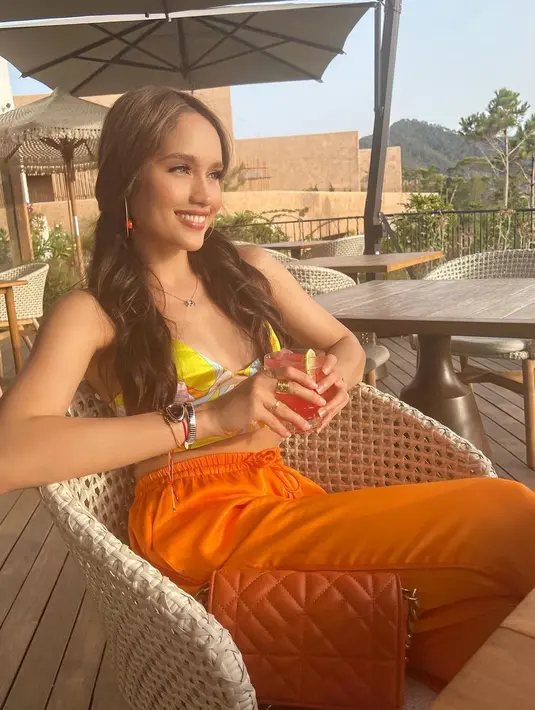 Cinta Laura saat menikmati desa nelayan yang indah sambil tersenyum. Laut sekaligus kota tua masih menjadi pemandangan yang dinikmati Cinta bareng sahabat. (Instagram/claurakiehl)