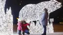 Orang-orang mengabadikan foto instalasi lampu yang dipasang untuk menyambut libur Tahun Baru dan Natal Ortodoks di Moskow, Rusia, pada 29 Desember 2020. (Xinhua/Alexander Zemlianichenko Jr)