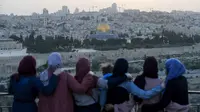 Warga Palestina berkumpul untuk berbuka puasa selama bulan suci Ramadan dengan latar belakang Kota Tua Yerusalem dan kompleks Masjid al-Aqsa yang ditutup selama krisis pandemi coronavirus yang baru di Bukit Zaitun (19/5/2020). (AFP/Ahmad Gharabli)