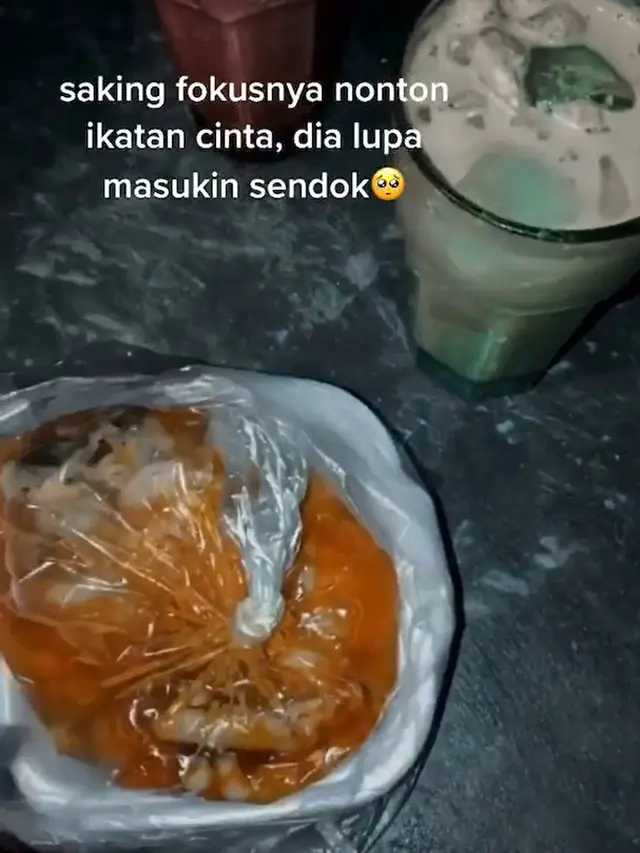 Seorang ibu streaming sinetron pakai ponsel di dekat kompor.