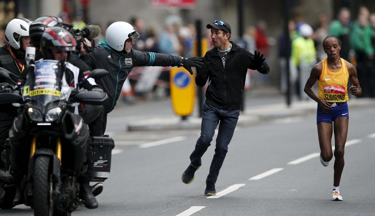 Seorang penonton masuk lintasamn saat pelari Kenya, Jemima Sumgong beraksi di kejuaraan Virgin Money London Marathon, London, (24/4/2016). (Reuters/Peter Cziborra)