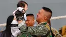 Ekspresi tentara Filipina saat mengendong anaknya anaknya setelah bertempur di kota Marawi melawan para militan di Manila, Filipina (30/10). Kota Marawi berhasil direbut dari para militan. (AP Photo / Bullit Marquez)