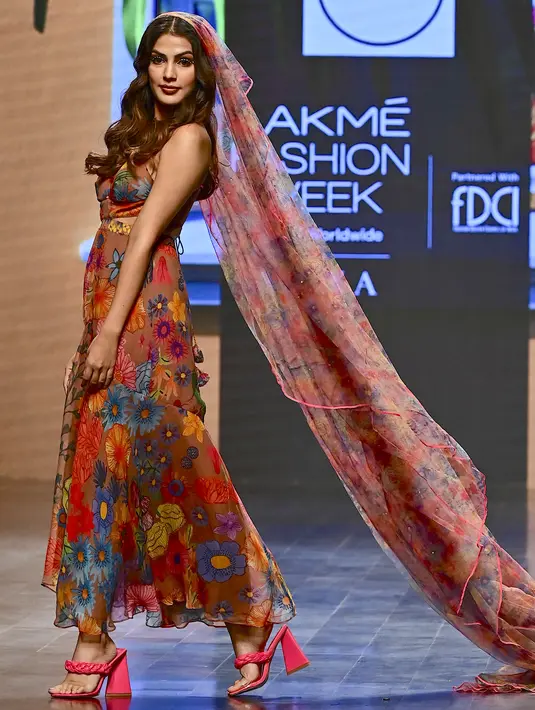 Rhea Chakraborty berjalan di catwalk mengenakan kreasi desainer Guapa selama FDCI X Lakme Fashion Week di Mumbai pada 14 Oktober 2022. Rhea tampil memukau mengenakan gaun bermotif bunga berwarna-warni. Keduanya tampil memukau dengan pakaian masing-masing. (AFP/Sujit Jaiswal)