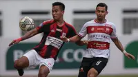 Pemain Persipura Jayapura, Muhammad Tahir (kiri) berebut bola dengan Pemain Madura United, Silvio Escobar Benitez dalam laga pekan ke-6 BRI Liga 1 2021/2022 di Stadion Wibawa Mukti, Cikarang, Minggu (03/10/2021). (Bola.com/Bagaskara Lazuardi)