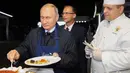 Presiden Rusia Vladimir Putin (kiri) menyantap pancake buatannya bersama Presiden China Xi Jinping di sela acara Eastern Economic Forum di Vladivostok, Rusia, Selasa (11/9). (Sergei Bobylev/TASS News Agency Pool Photo via AP)