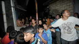 Puluhan warga terlihat mengerumuni rumah terduga teroris usai penggerebekan yang dilakukan Densus 88 Anti Teror Mabes Polri, Jakarta, Selasa (24/6/14). (Liputan6.com/Johan Tallo)