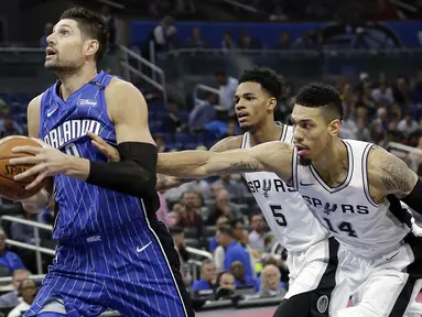 Pebasket San Antonio Spurs, Dejounte Murray dan Danny Green, berusaha merebut bola dari Orlando Magic, Nikola Vucevic, pada laga NBA di Amway Center, Sabtu (28/10/2017). San Antonio Spurs takluk 87-114 dari Orlando Magic. (AP/John Raoux)