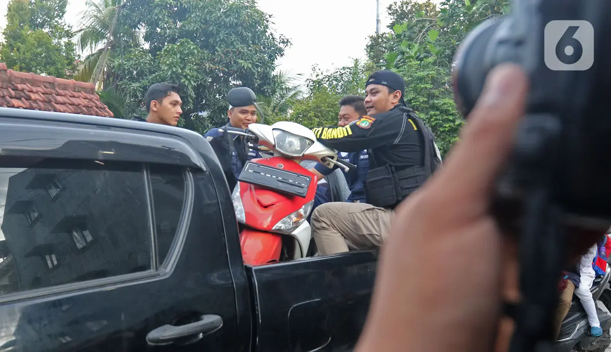 Petugas kepolisian membawa motor tersangka penyiraman air keras seusai rekonstruksi kasus penyerangan terhadap penyidik KPK Novel Baswedan di Jalan Deposito, Kelapa Gading, Jakarta, Jumat (7/2/2020). Rekonstruksi penyiraman air keras ke Novel Baswedan digelar tertutup. (Liputan6.com/Herman Zakharia)