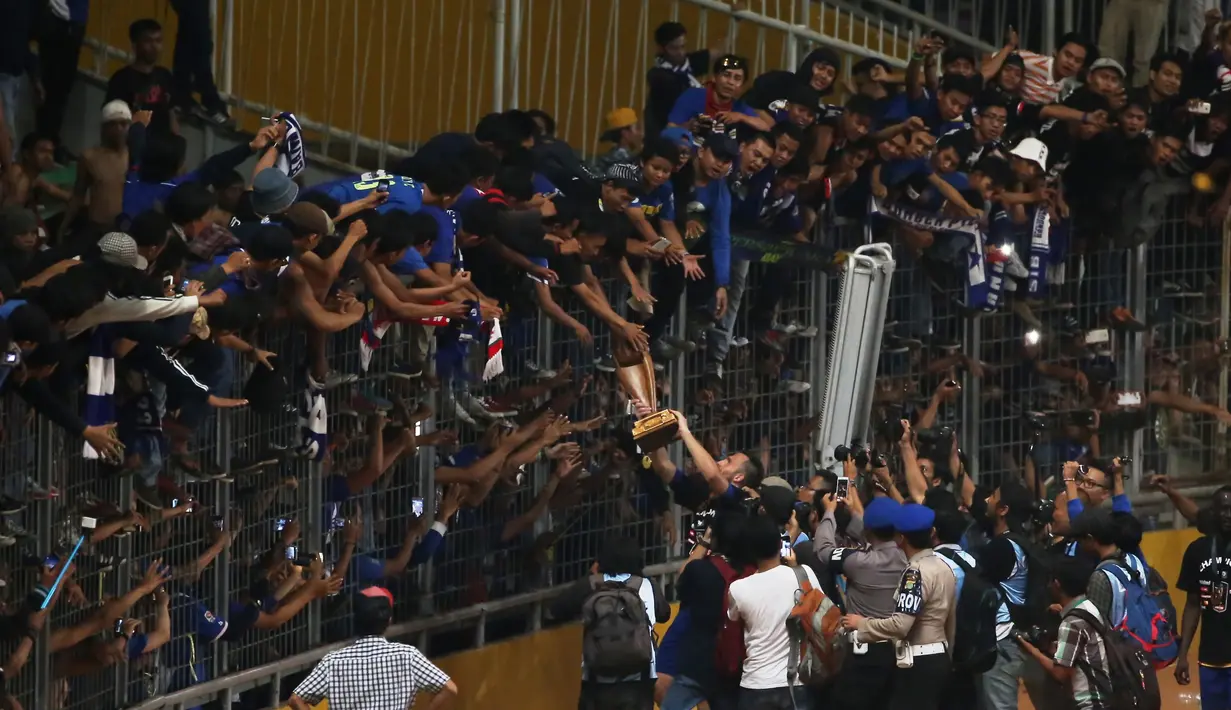 Aksi Suporter saat memegang Piala Presiden 2015 di Stadion Gelora Bung Karno, Jakarta, Minggu (18/10/2015). (Bola.com/Nicklas Hanoatubun).