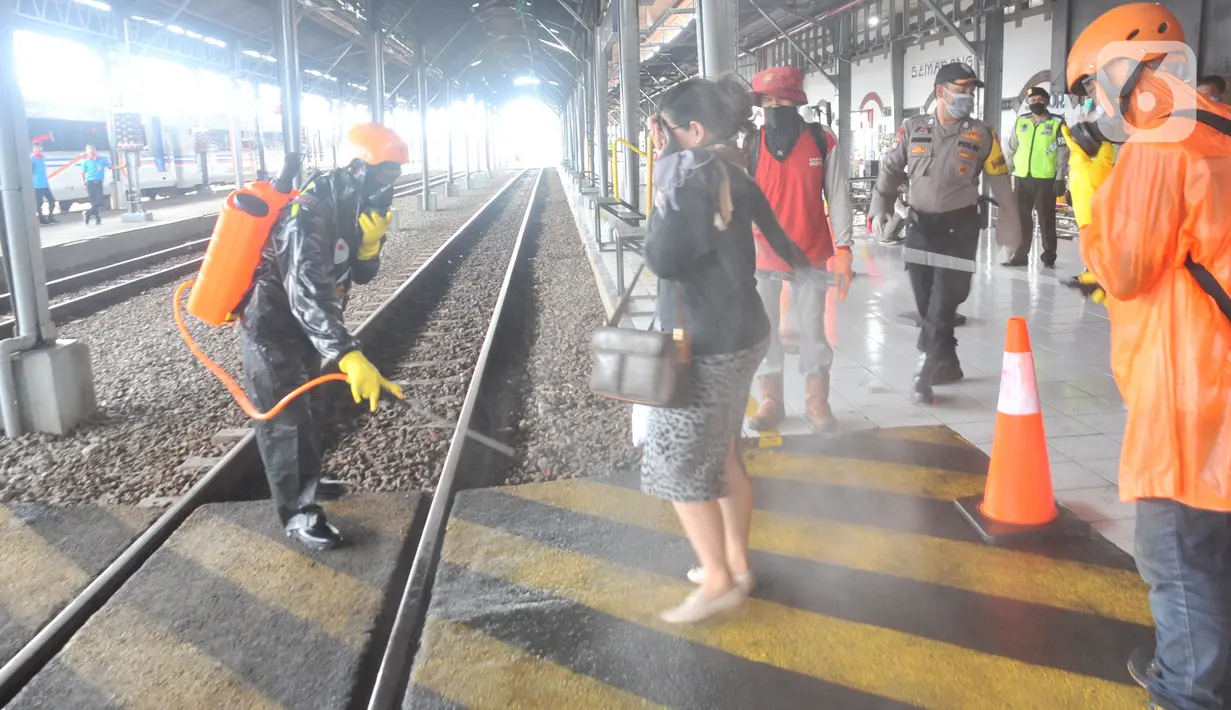 Petugas menyemprotkan larutan disinfektan kepada penumpang yang turun di Stasiun Kereta Api (KA) Tawang, Semarang, Sabtu (28/3/2020). Selain sterilisasi, petugas juga melakukan pencatatan penumpang yang turun untuk data pengawasan guna menekan penularan Virus Corona (COVID-19) (Liputan6.com/Gholib)