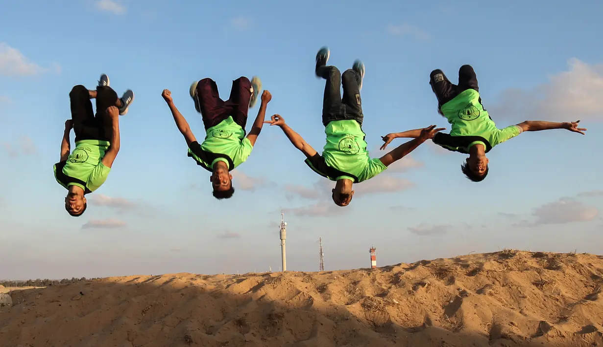 Empat pemuda Palestina mempraktekkan keterampilan parkour mereka di dekat tenda warga di perbatasan Gaza, Palestina (10/4). Mereka menunjukkan keterampilan parkour kepada warga yang menggelar tenda di perbatasan Gaza. (AFP Photo/Said Khatib)