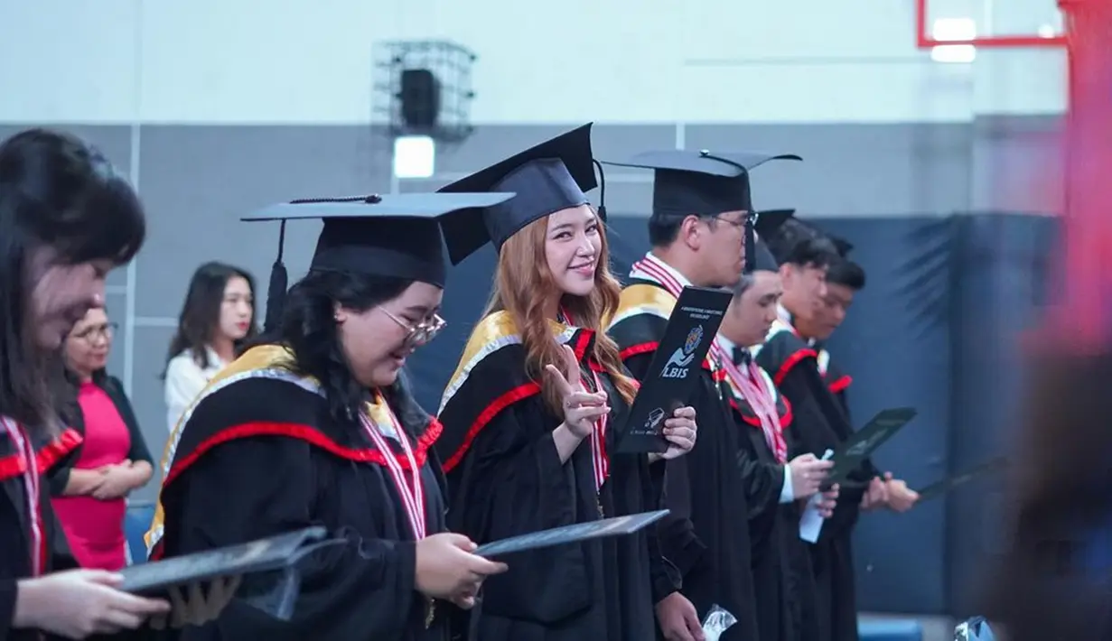Tampak Anneth yang begitu bahagia di hari wisudanya. Ia tampil penuh karisma dengan balutan baju dan topi wisuda. Pemenang ajang pencarian bakat Indonesian Idol Junior musim ketiga itu berdiri berjajar bersama teman-temannya setelah menerima piagam kelulusan sekolah. (Liputan6.com/IG/@anneth.dlc)