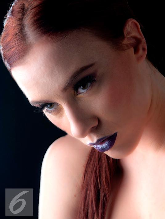 Untuk memberi kesan sensual pada tampilan, Anda dapat menggunakan lipstik warna burgundy atau merah marun. Untuk tampilan yang lebih simpel, padukan dengan riasan mata dengan eyeshadow nude dan eyeliner cateyes. (Liputan6.com/Yudha Gunawan)