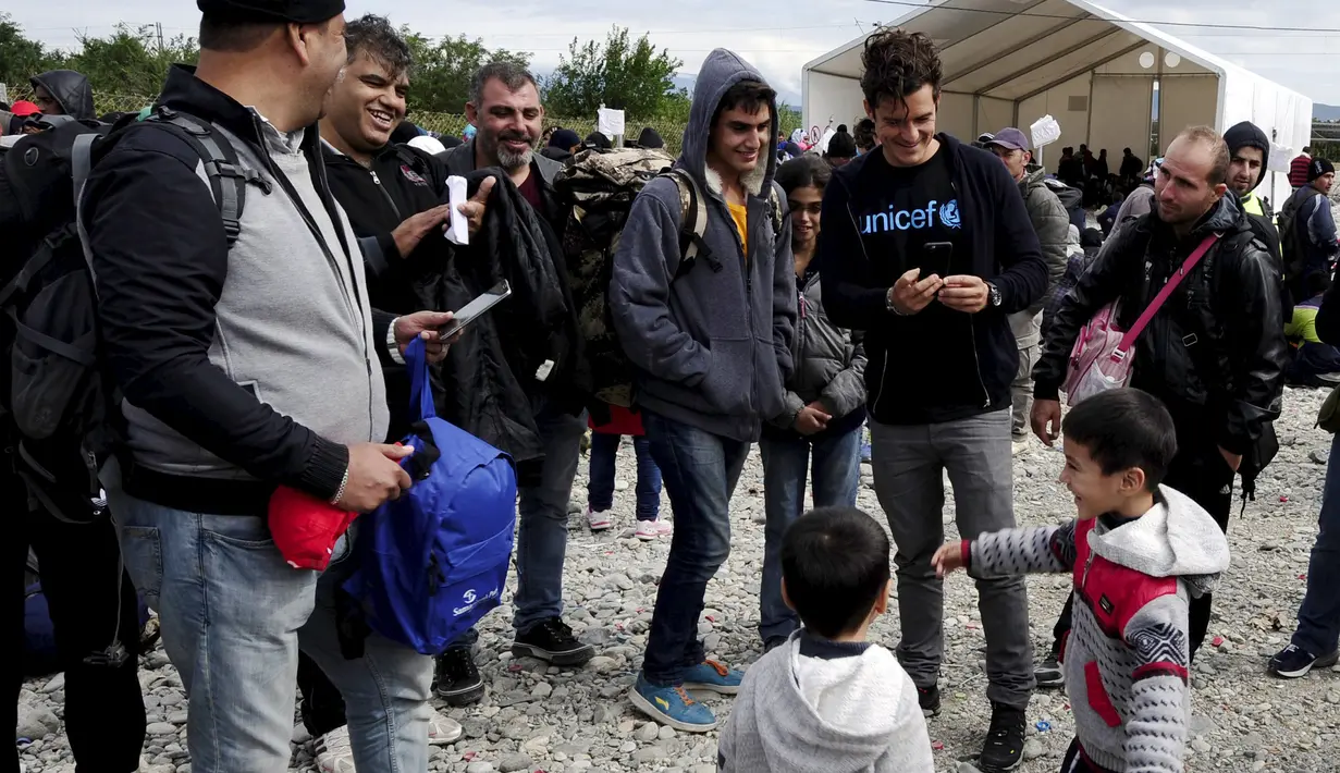 Duta UNICEF, Aktor Orlando Bloom mengambil foto sejumlah anak saat mengunjungi kamp transit migran di Gevgelija, Makedonia, 29 September 2015. (REUTERS/Ognen Teofilovski)