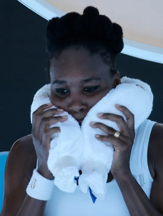 Petenis wanita asal AS, Venus Williams meletakkan handuk ber isi es di lehernya saat istirahat melawan petenis Jerman, Mona Barthel pada kejuaraan tenis Australia Terbuka di Melbourne, Australia, (22/1). (AP Photo/Aaron Favila)