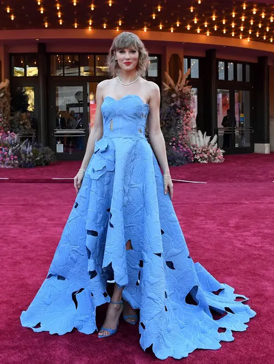 <p>Flash kamera yang tak henti serta pujian dan tepuk tangan meriah membuat senyum Taylor Swift semakin lebar. (VALERIE MACON/AFP)</p>