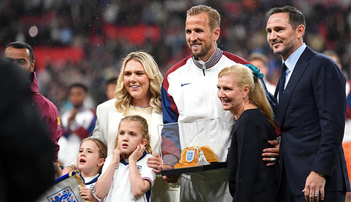 Pemain Inggris, Harry Kane berfoto bersama keluarganya saat menerima Cap ke-100 sebelum laga UEFA Nations League 2024 antara Inggris melawan Finlandia di Satdion Wembley, London, Rabu (11/09/2024) WIB. (AFP/Justin Tallis)