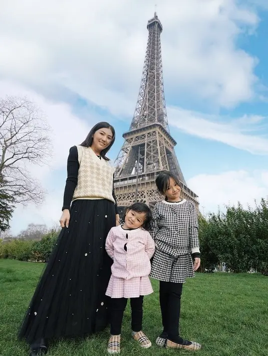 Tak lengkap rasanya jika ke Paris tanpa berfoto di menara  Eiffel. Sarwendah dengan atas vest kotak-kotak dan inner hitam, dipadukan rok tulle berkilau pun foto di bawah menara Eiffel bersama kedua anaknya. @sarwendah29