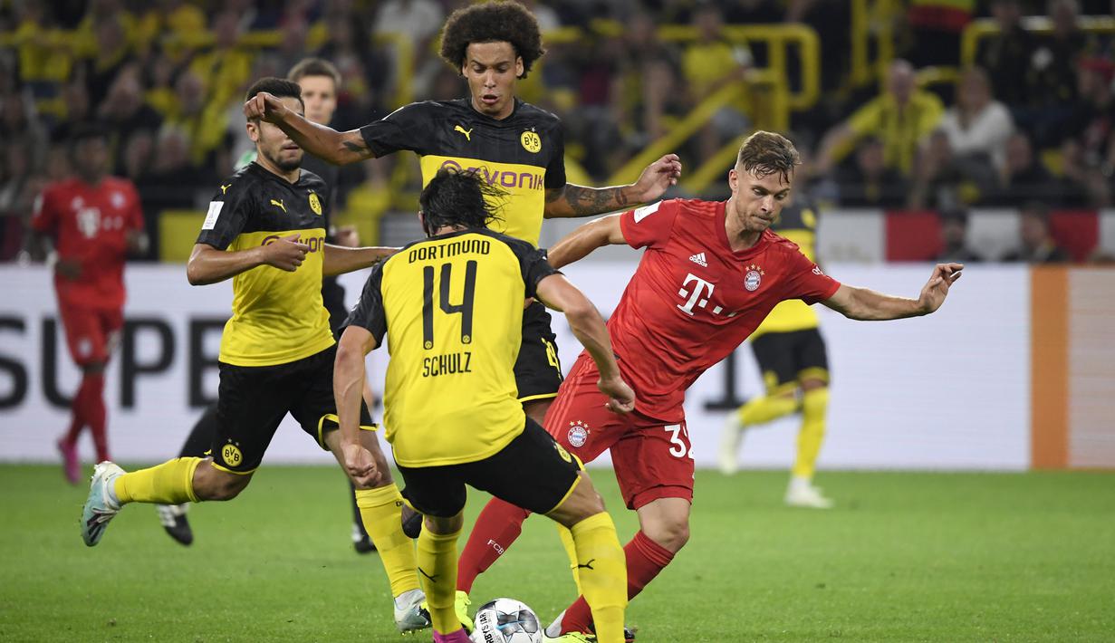 Bek Dortmund, Nico Schulz, berusaha merebut bola dari bek Bayern Munchen, Joshua Kimmich, pada laga Piala Super DFL di Stadion Signal Iduna, Dortmund, Sabtu (3/8). Dortmund menang 2-0 atas Munchen. (AFP/Ina Fassbender)