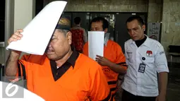 Syamsir Yusfan dan Dermawan Ginting menutup mukanya dengan kertas usai menjalani pemeriksaan di Gedung KPK, Jakarta, Jumat (27/7/2015). Mereka diperiksa terkait sengketa Bantuan Sosial dan Bantuan Daerah Bawahan (BDB) Sumut. (Liputan6.com/Yoppy Renato)
