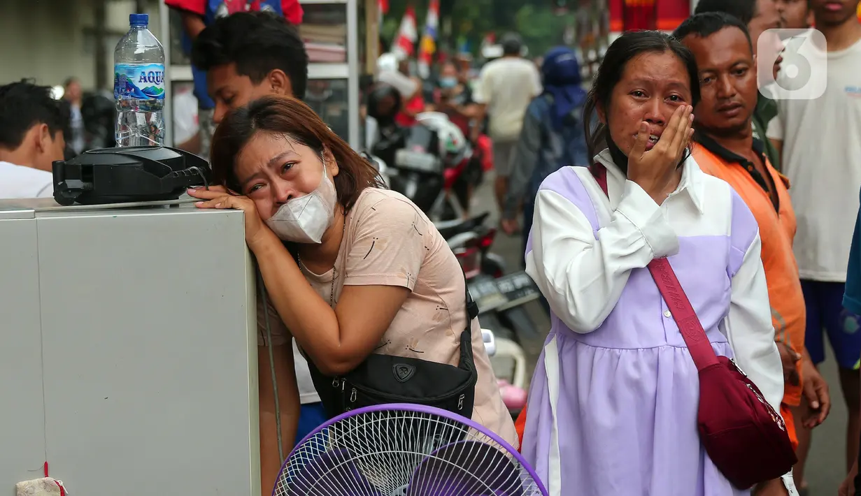 Warga menangis histeris saat terjadi kebakaran di kawasan padat penduduk di Jalan Simprug Golf II RT 4/8, Grogol Selatan, Kebayoran Lama, Jakarta Selatan, Minggu (21/8/2022). Hingga siang ini, petugas pemadam kebakaran bersama warga masih terus berusaha untuk memadamkan api. (Liputan6.com/Angga Yuniar)