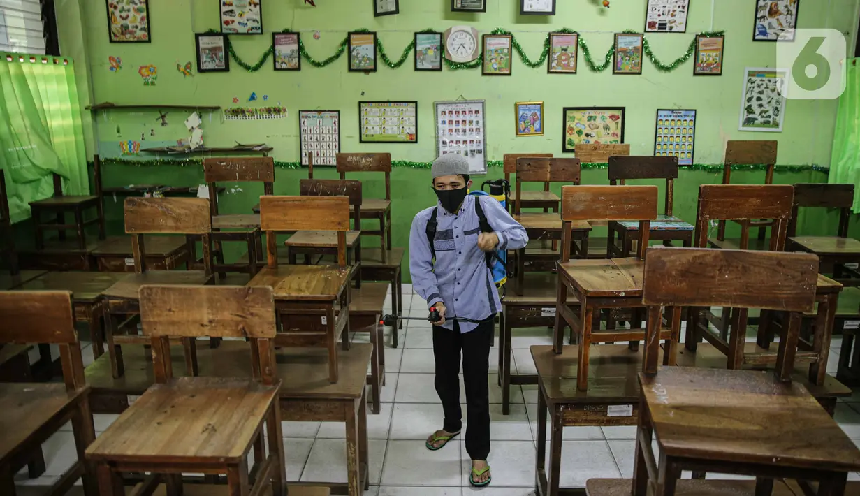 Petugas menyemprotkan disinfektan di kelas SD Negeri Kota Bambu 03/04, Jakarta, Sabtu (21/11/2020). Pemerintah pusat memberikan kewenangan pemerintah daerah membuka sekolah dan melakukan pembelajaran tatap muka pada semester genap tahun ajaran 2020/2021. (Liputan6.com/Faizal Fanani)