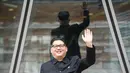 Howard X yang mirip Kim Jong-un melambai ke luar gedung di Hong Kong (7/6). Ketika dunia menunggu pertemuan bersejarah antara Presiden AS Donald Trump dan Kim Jong Un, Howard X akan tampil di Singapura. (AFP Photo/Anthony Wallace)