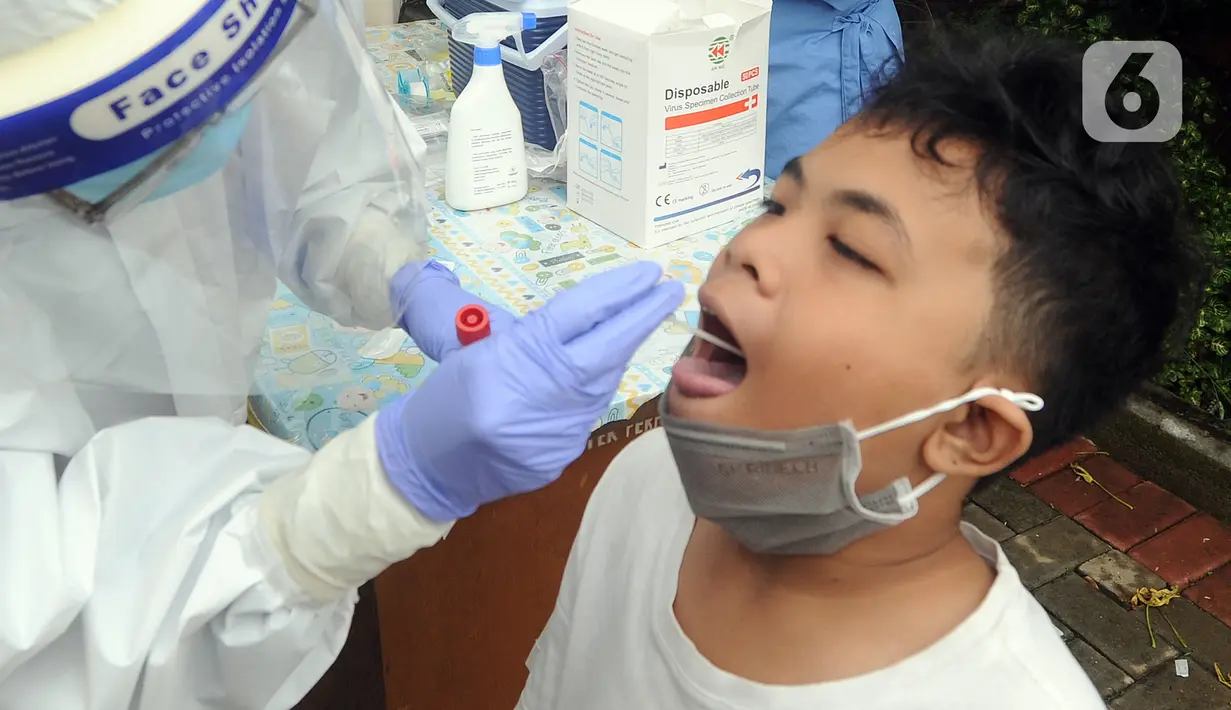 Ekspresi seorang anak saat menjalani swab test massal di Puskesmas Ciganjur, Jakarta Selatan, Kamis (7/1/2020). Swab test gratis tersebut dilakukan untuk screening memetakan penyebaran COVID-19 di Kelurahann Ciganjur. (merdeka.com/Arie Basuki)