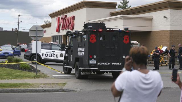 Kerumunan berkumpul saat polisi menyelidiki penembakan di supermarket Tops pada Sabtu, 14 Mei 2022, di Buffalo, NY. (Foto AP/Joshua Bessex)