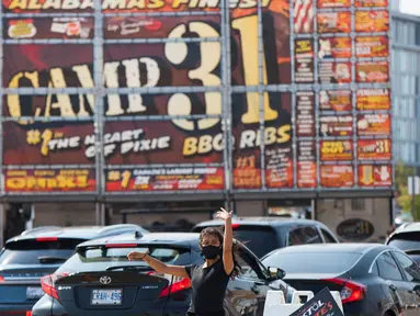 Seorang staf mengarahkan para pengemudi mobil dalam acara drive-thru Scarborough Ribfest 2020 di Toronto, Kanada, pada 27 September 2020. Akibat pandemi COVID-19, festival makanan itu hanya digelar dalam format drive-thru  tahun ini mulai Sabtu (26/9) hingga Minggu (27/9). (Xinhua/Zou Zheng)