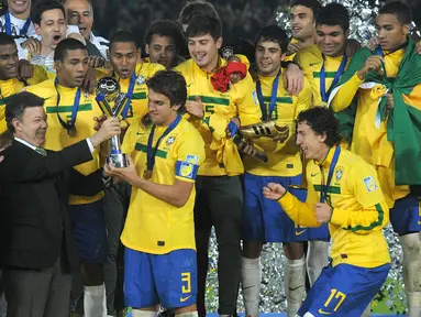Kapten Timnas Brasil U-20, Bruno Uvini (tengah), menerima trofi Piala Dunia U-20 2011 setelah mengalahkan Portugal U-20 yang berlangsung di Bogota, Kolombia, Sabtu (20/8/2011). Brasil menang 3-2 atas Portugal lewat babak perpanjangan waktu. (AFP/Eitan Abramovich)