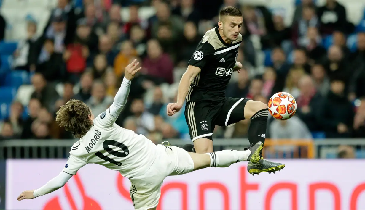 Gelandang Real Madrid Luka Modric (kiri) mencoba menghentikan pemain depan Ajax Amsterdam Dusan Tadic saat berlaga dalam leg kedua babak 16 besar Liga Champions di Stadion Santiago Bernabeu, Madrid, Spanyol, Selasa (5/3). (AP Photo/Bernat Armangue)