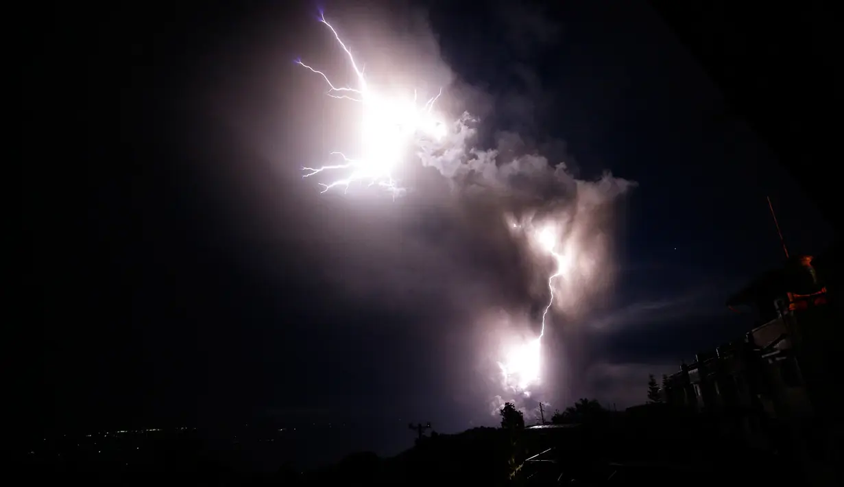 Petir menyambar saat Gunung Api Taal erupsi di Tagaytay, Provinsi Cavite, Filipina, Minggu (12/1/2020). Pejabat penerbangan memerintahkan penangguhan penerbangan dari dan ke Bandara Internasional Ninoy Aquino di Manila. (AP Photo/Aaron Favila)